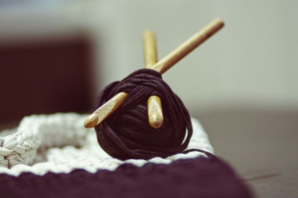 Angora Yarn - brown yarn roll with two brown crochet hooks on top of white surface