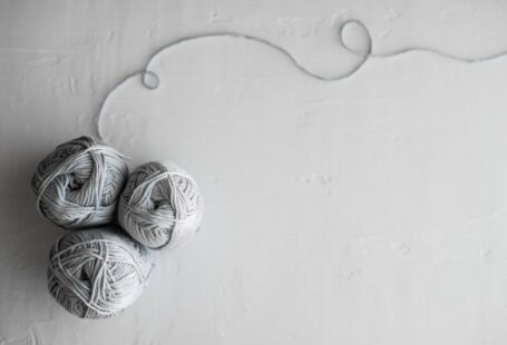 Yarn Tools - flat lay photography of three white yarn balls