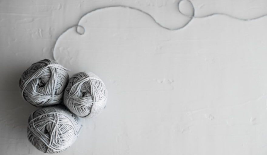 Yarn Tools - flat lay photography of three white yarn balls