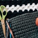 Yarn Tools - green scissors besides knitting sticks