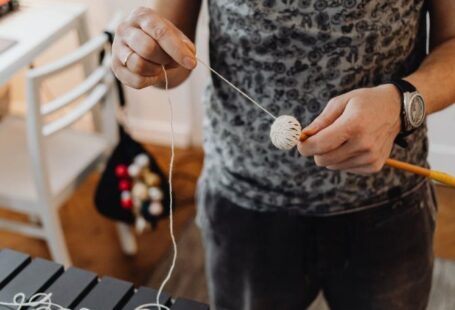 Yarn Tools - A Person Holding a Stick and Yarn