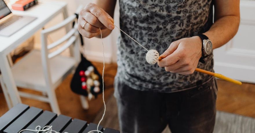 Yarn Tools - A Person Holding a Stick and Yarn