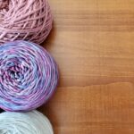 Silk Yarn - a group of balls of yarn sitting on top of a wooden table