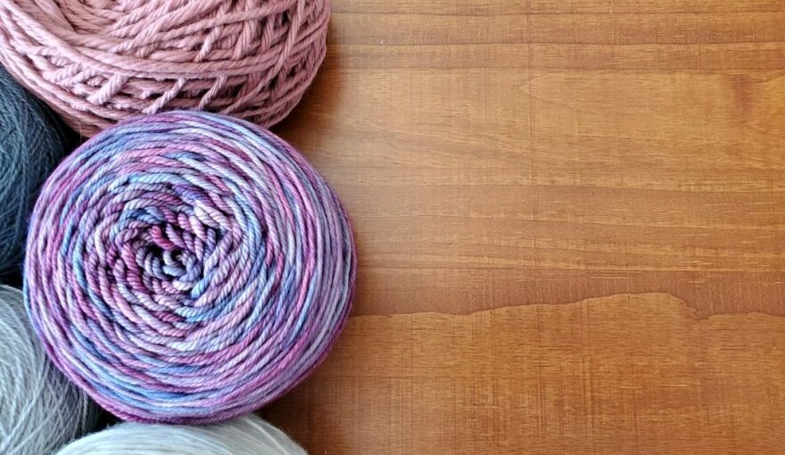 Silk Yarn - a group of balls of yarn sitting on top of a wooden table