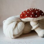 Yarn Tools - a white ball of yarn with a red mushroom on top of it