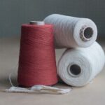 Cotton Yarn - red thread on brown wooden table