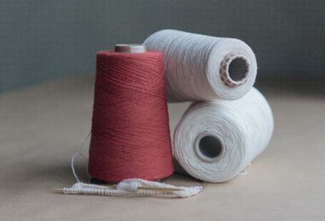 Cotton Yarn - red thread on brown wooden table