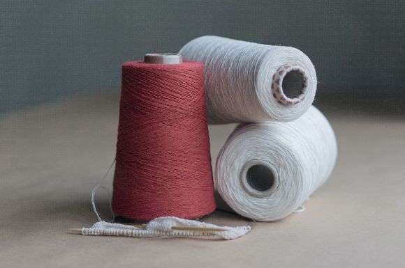 Cotton Yarn - red thread on brown wooden table