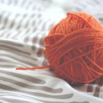 Yarn Tools - orange yarn ball on white and gray pad