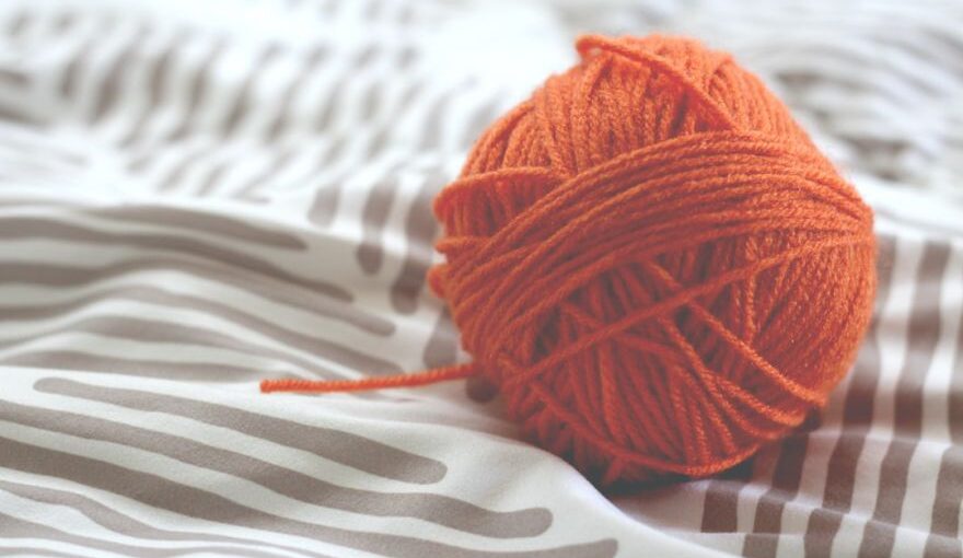 Yarn Tools - orange yarn ball on white and gray pad